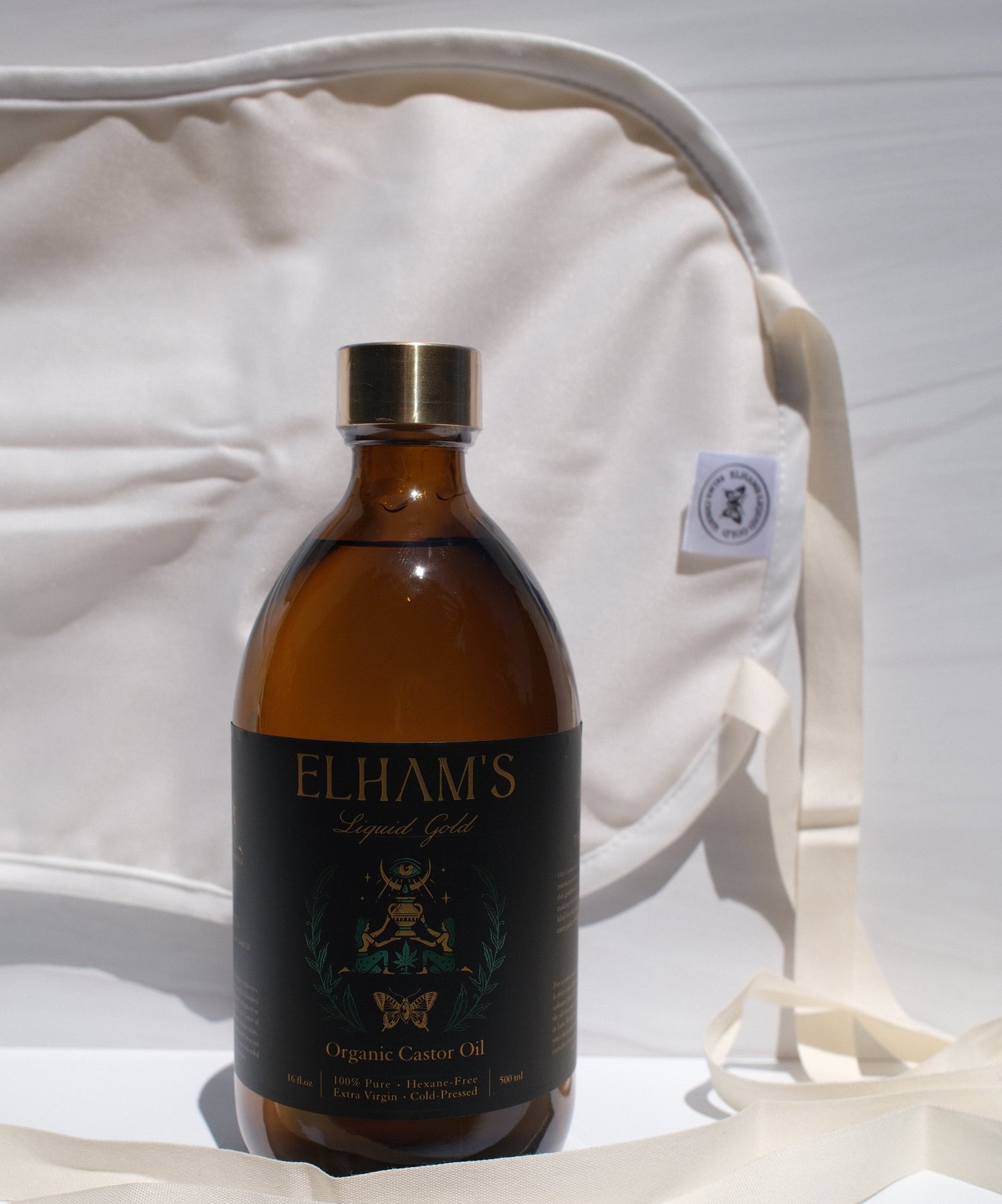 A bottle of Organic Castor Oil alongside a Castor Oil Pack with a soft inner layer of organic cotton and a mess-resistant outer layer.
